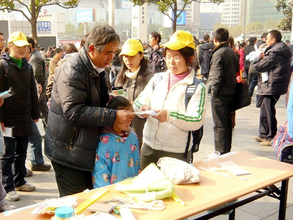 yl23455永利官网大学生志愿者为市民讲解服务